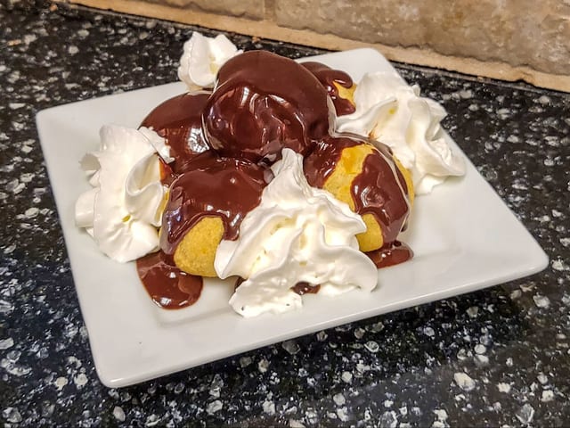 Profiteroles (5) Cream Puffs Dressed with Italian Chocolate Sauce.